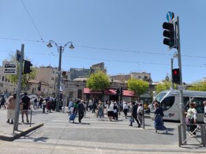 עוברים ושבים חוצים את הכביש ליד תחנת כיכר ציון בירושלים, יום אחרי חג העצמאות 2025