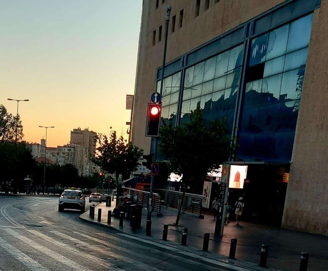 צילום של התחנה המרכזית בירושלים עם רמזור אדום ברקע, בשעת ערב, מבט מהרחוב לעבר הבניין