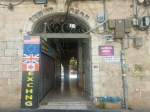 שער ישן ברחוב יפו בירושלים, עם שלטים ודגלי מדינות מהתפוצות, כסמל לחיבור בין יהדות העולם לבין העיר ירושלים.
