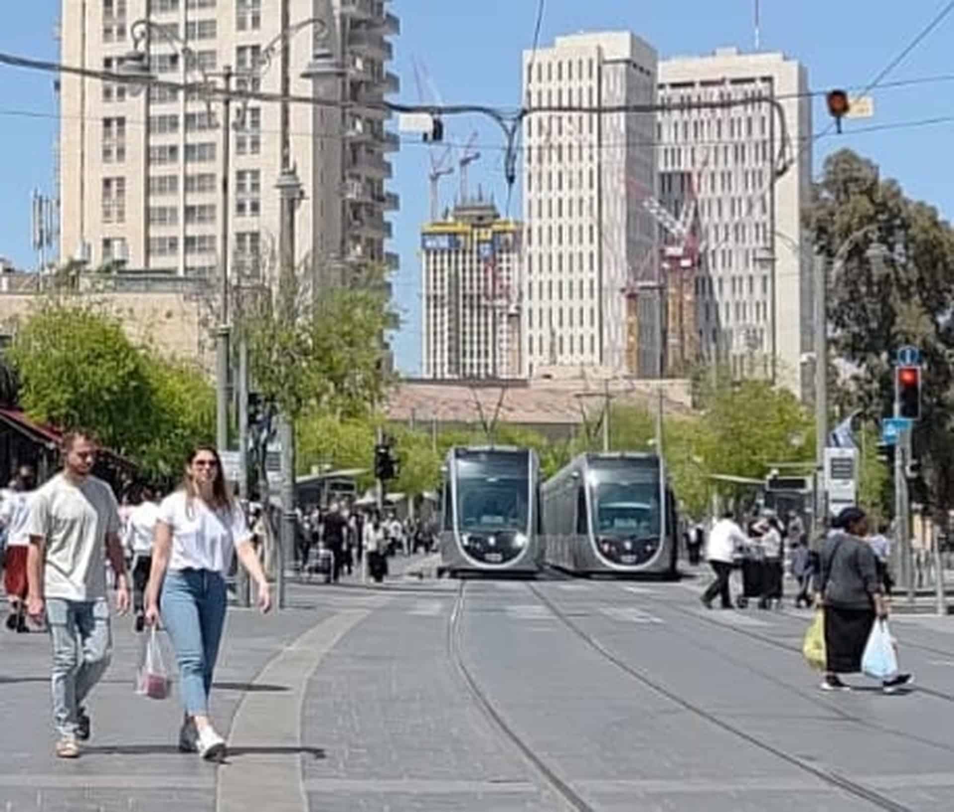 רכבת קלה ברחוב יפו בירושלים עם הולכי רגל, רקע של מגדלים
