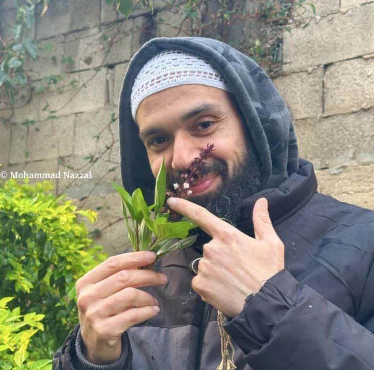 סאמח אל-שובאקי, אסיר משוחרר מקלקיליה, מחזיק צמח בגינה ומתבונן למצלמה
