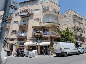 דגלי ישראל דהויים על מרפסות בשכונת מגורים בירושלים, יום אחרי החג