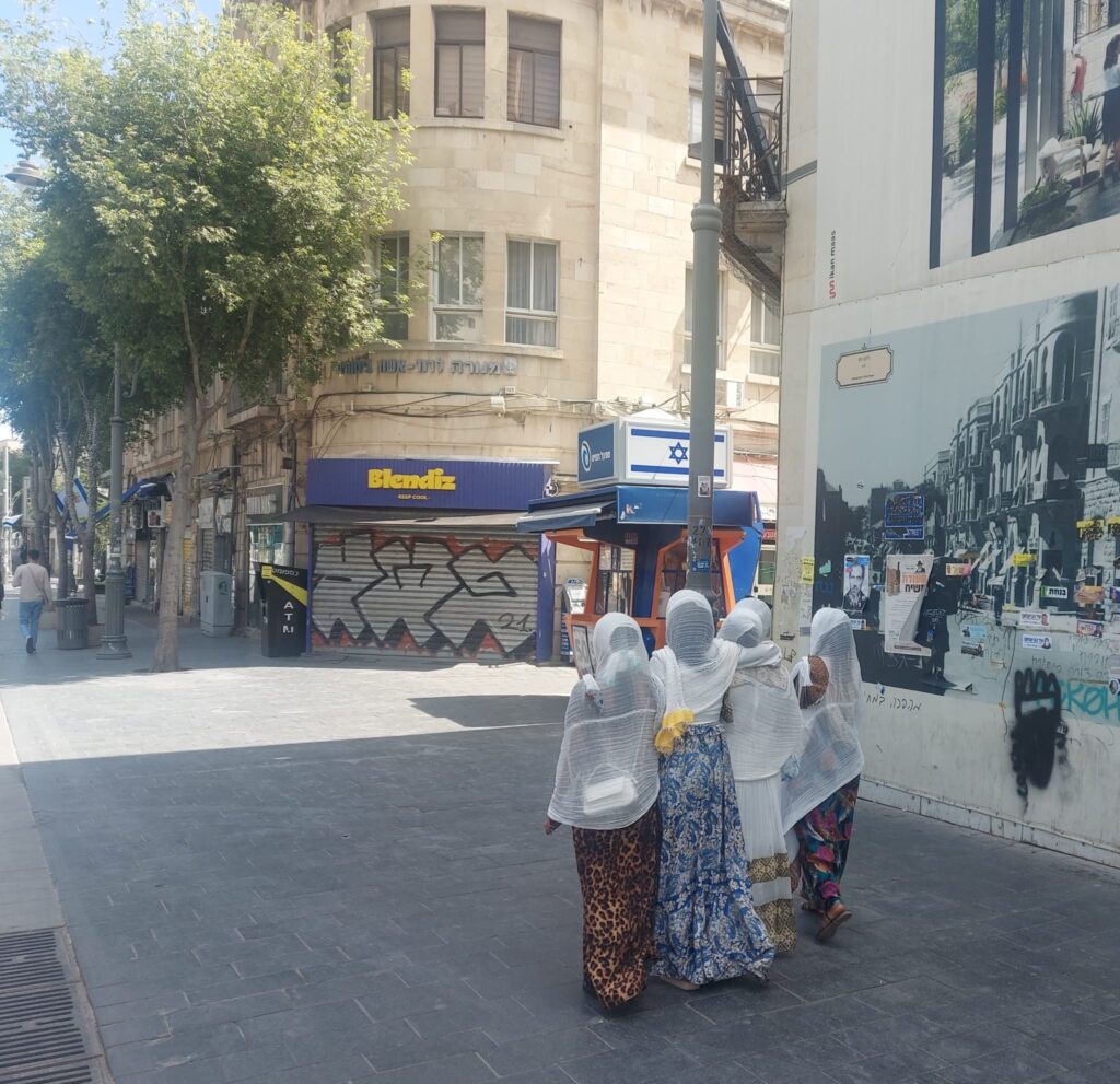 תמונה של אנשים הולכים ברחוב יפו בירושלים, המייצגת את הפסיפס האנושי ואת חיי היום יום התוססים בעיר.