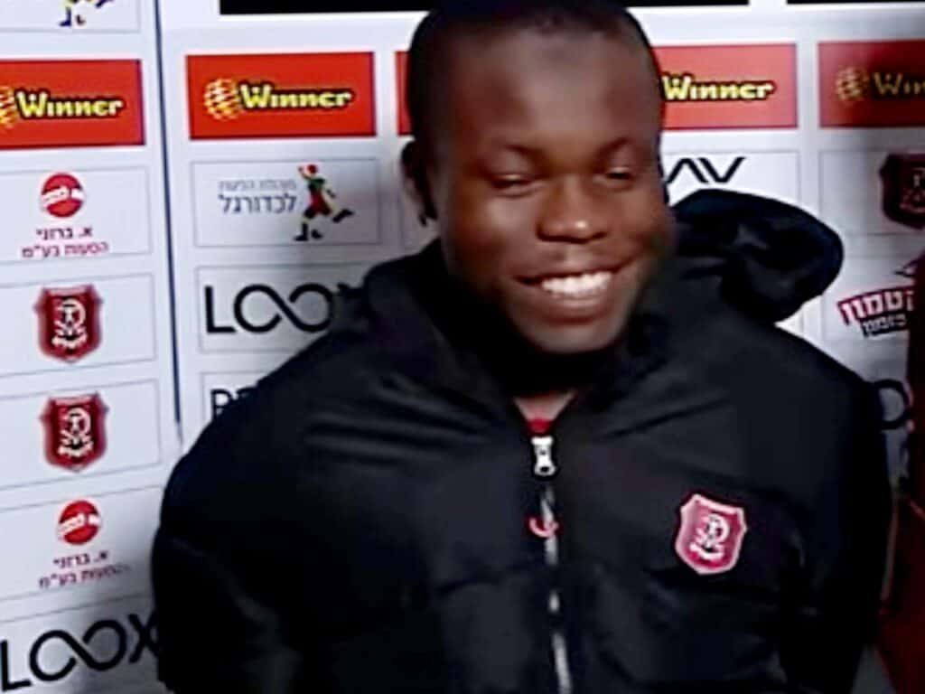 Cedric Don of Hapoel Jerusalem in front of sponsor backdrop, smiling after match – Sport Channel screenshot