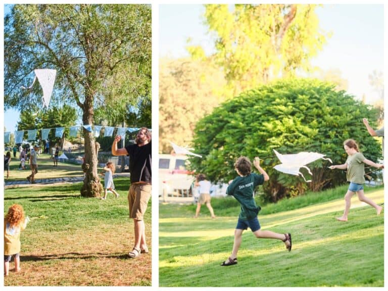 Children and parents fly handmade kites during a summer event in Bloomfield Garden, Jerusalem