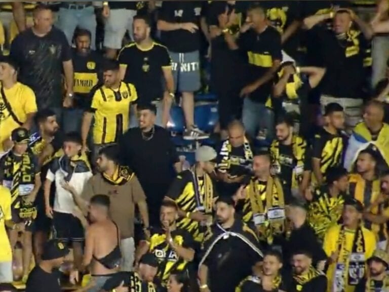 Beitar Jerusalem fans in yellow and black cheering passionately in the stands during the Conference League match in Bucharest