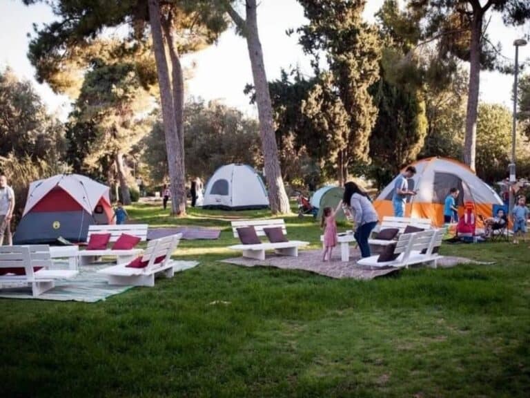 Tents and families gathered in a Jerusalem neighborhood park during a community camping night am