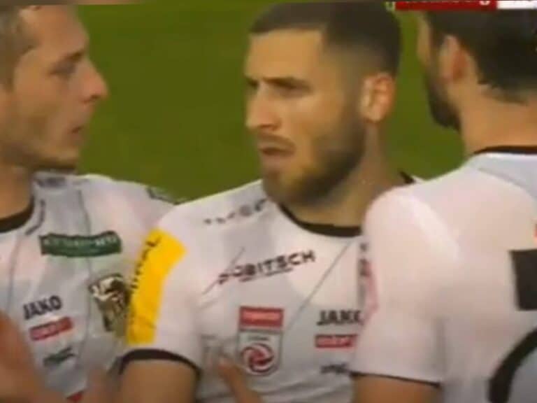 Shon Weissman surrounded by teammates in a tense football moment, illustrating the controversy around his transfer he