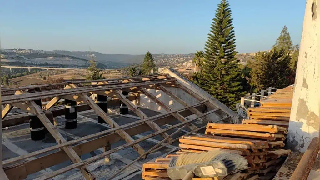 Pekerja di Baitulmaqdis sedang menyalut bumbung sebelum musim hujan