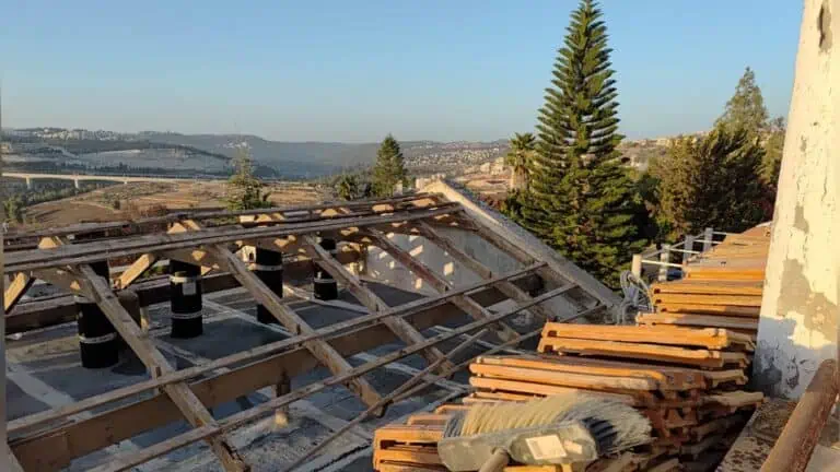 Pekerja di Baitulmaqdis sedang menyalut bumbung sebelum musim hujan